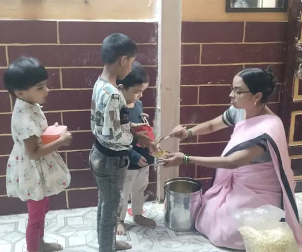 A volunteer serving a nutritious meal to children